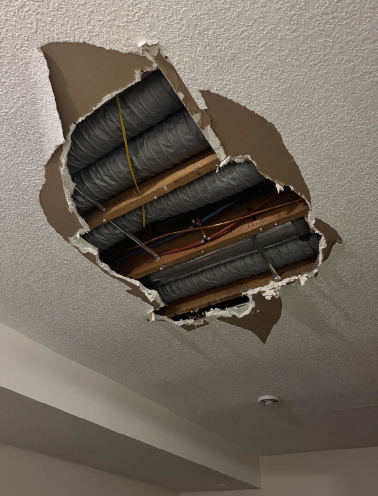 Drywall hole being patched and feathered with joint compound